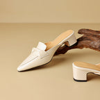 "Marloe Spitz zulaufende Leder-Mules" could be rewritten as "Marloe Elegante Leder-Mules mit spitz zulaufendem Design".