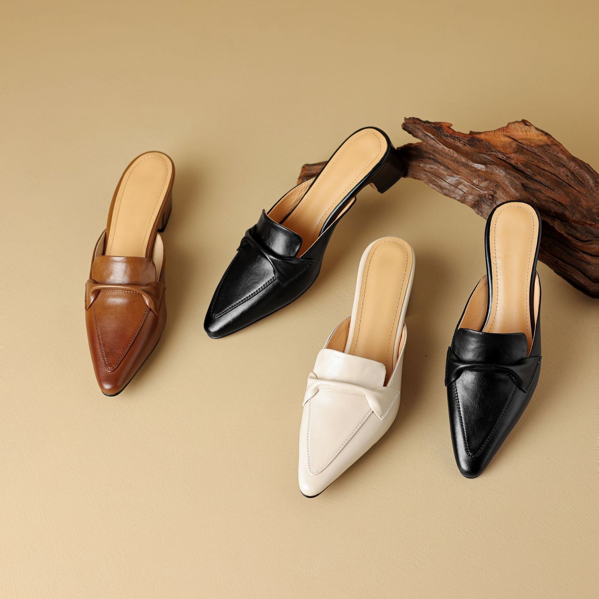 "Marloe Spitz zulaufende Leder-Mules" could be rewritten as "Marloe Elegante Leder-Mules mit spitz zulaufendem Design".